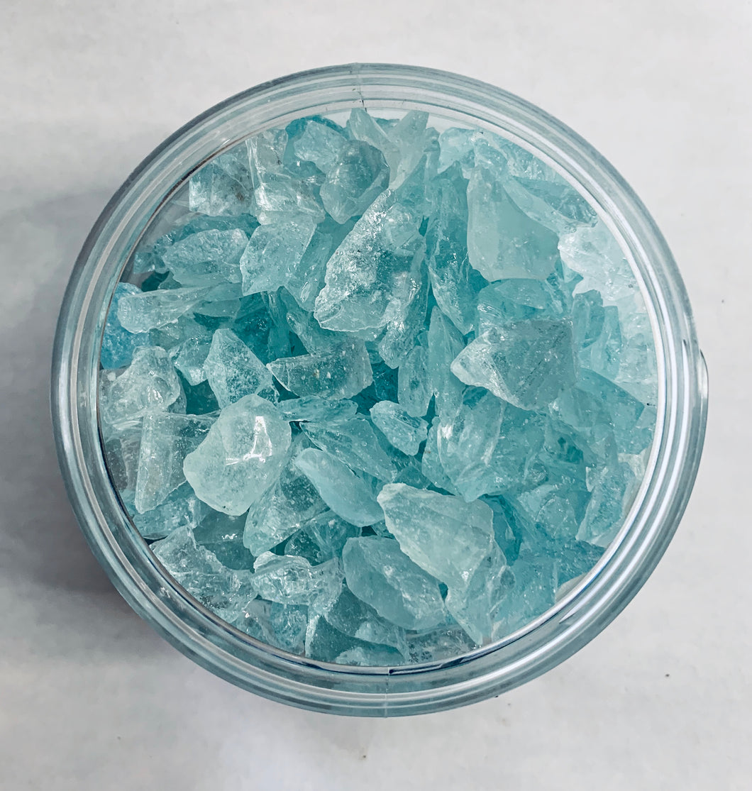 A gods-eye view of a jar of tumbled pieces of glass, a very light sky blue color.