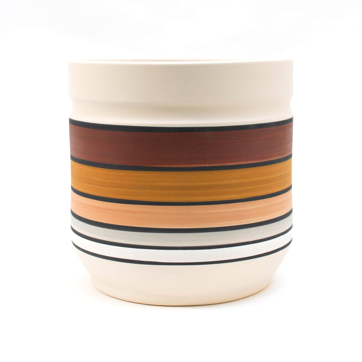 Desert Planter: A large cylindrical planter which is unglazed and painted with horizontal stripes. Each large stripe is a different color, with thinner black stripes dividing each color. From top to bottom: white, dark brown, dark tan, beige, light grey, and white.