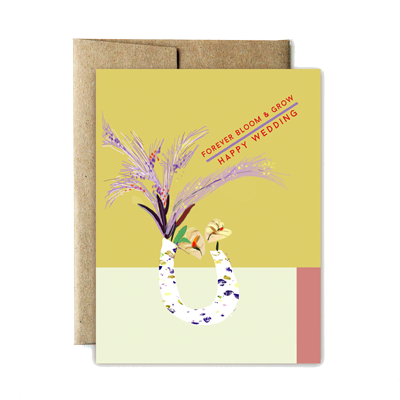 The front of this card depicts a speckled U-shaped vase with a flower arrangement coming out of both openings. The arrangement consists of two creamy anthurium flowers, with lavender foliage. Text moving upwards diagonally above the arrangement reads: 