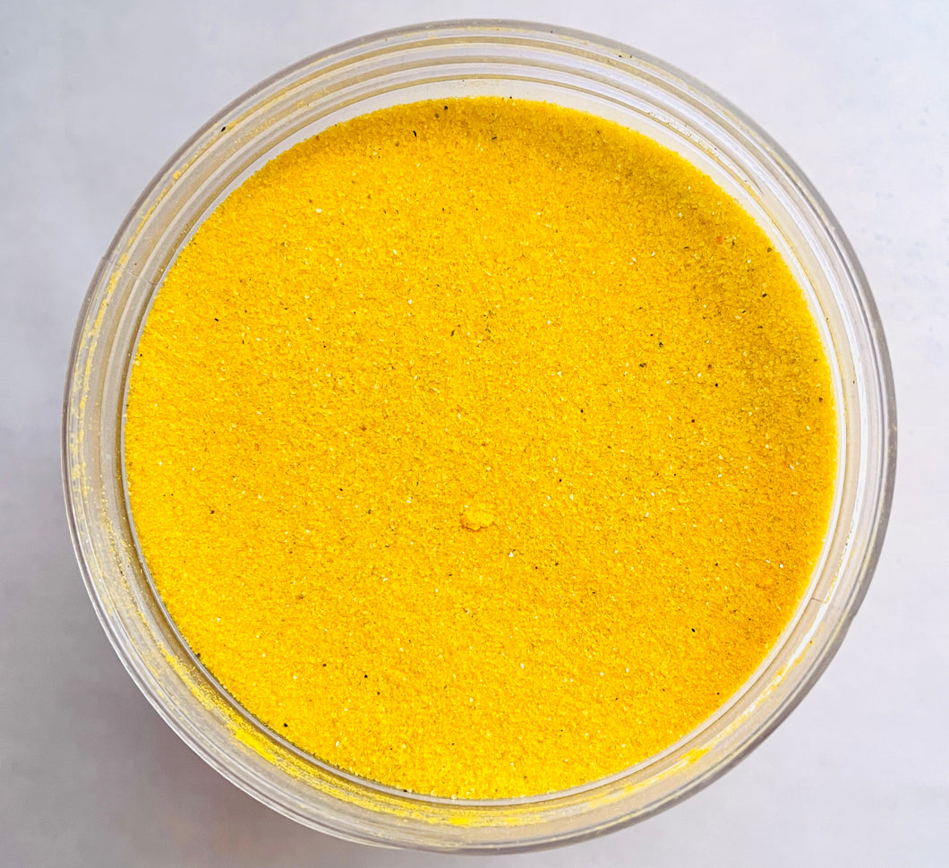 Fluorescent Orange Sand: a gods-eye view of a clear jar filled with bright yellow-orange sand.