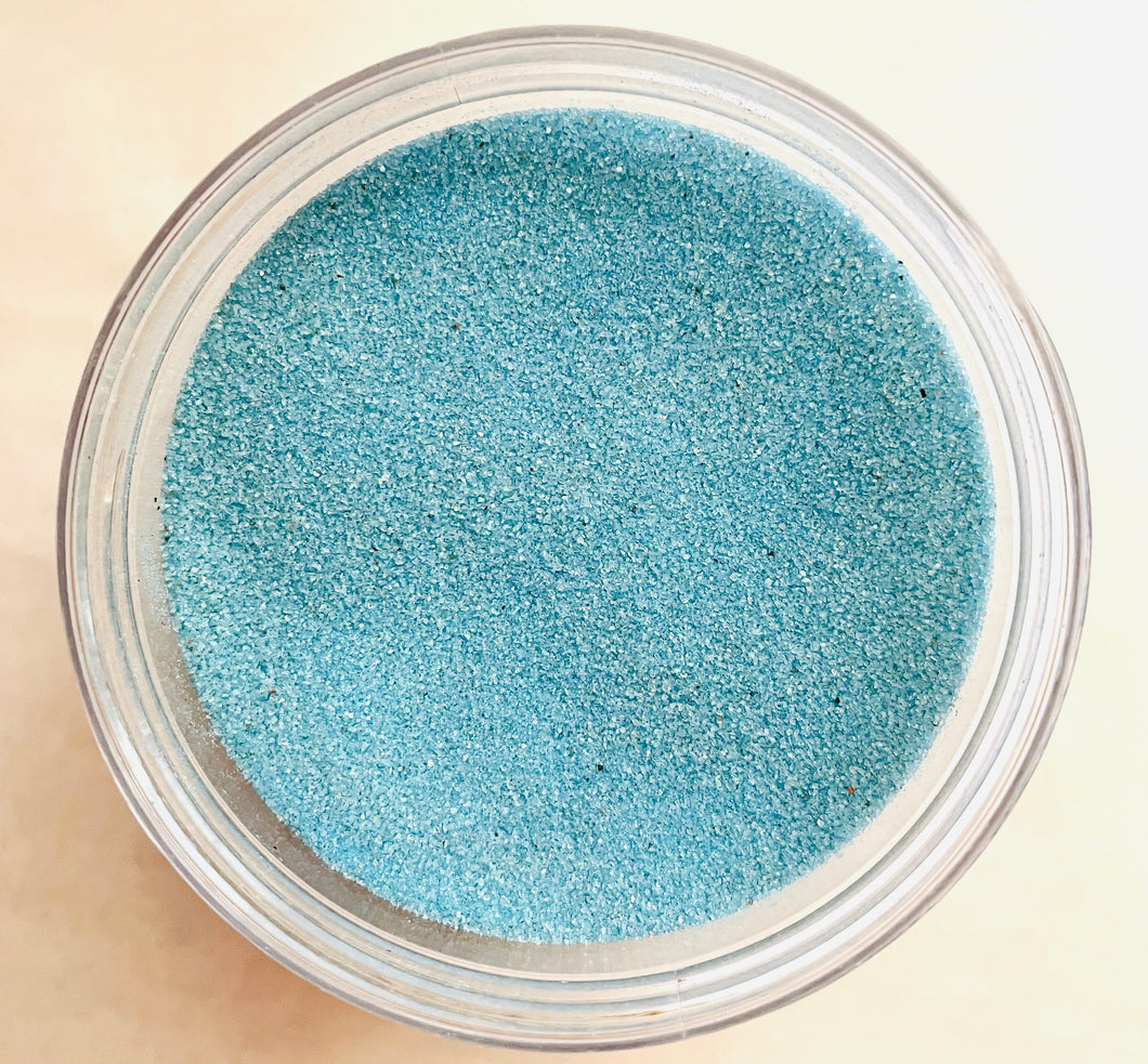 Light Blue Sand: a gods-eye view of a clear jar filled with light sky blue sand.