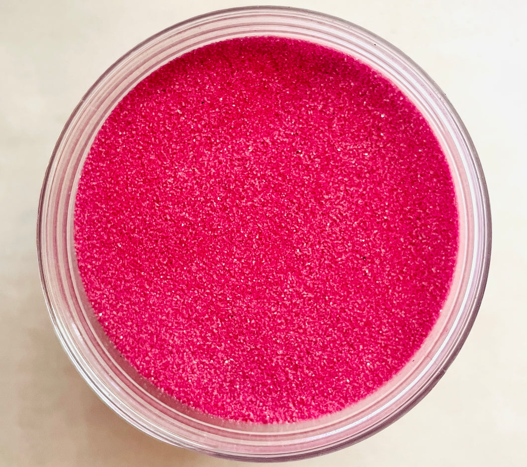 Mauve Sand: a gods-eye view of a clear jar of deep pink sand.