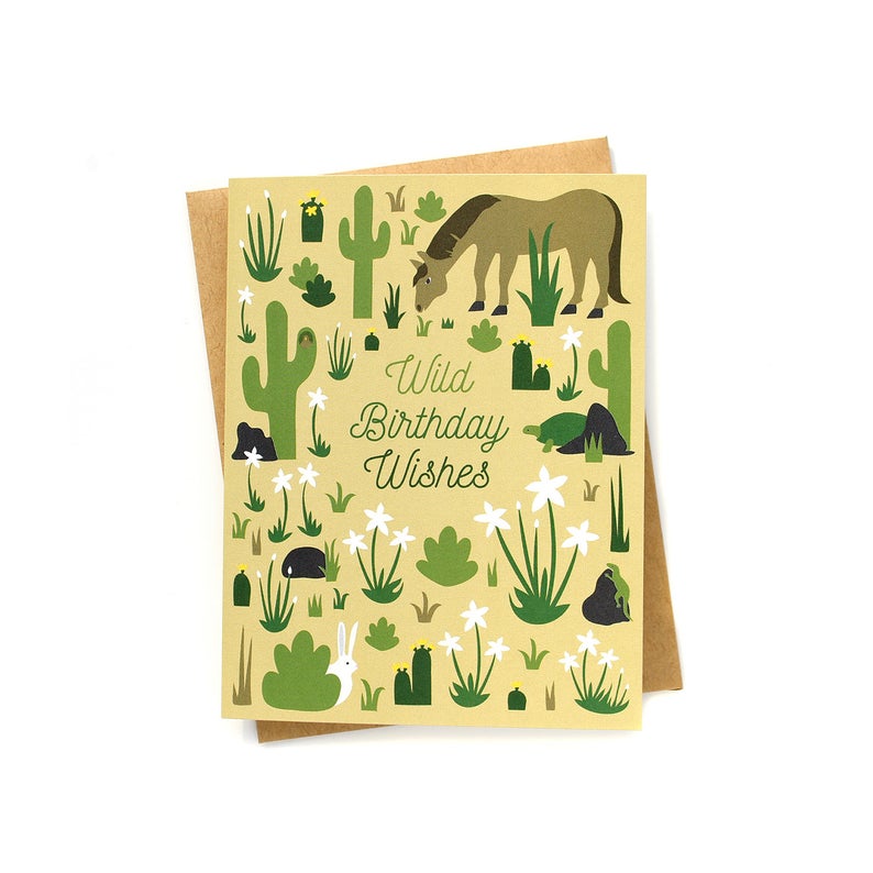 The front of this card depicts a desert filled with green cacti and succulents. Scattered throughout are various animals, most prominently a horse in the upper right corner. Cursive script in the center reads: 