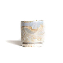 Load image into Gallery viewer, Marble: this cylindrical planter has a swirling pattern, made up of different hues of white, gold, and blue. It has a very glossy finish.
