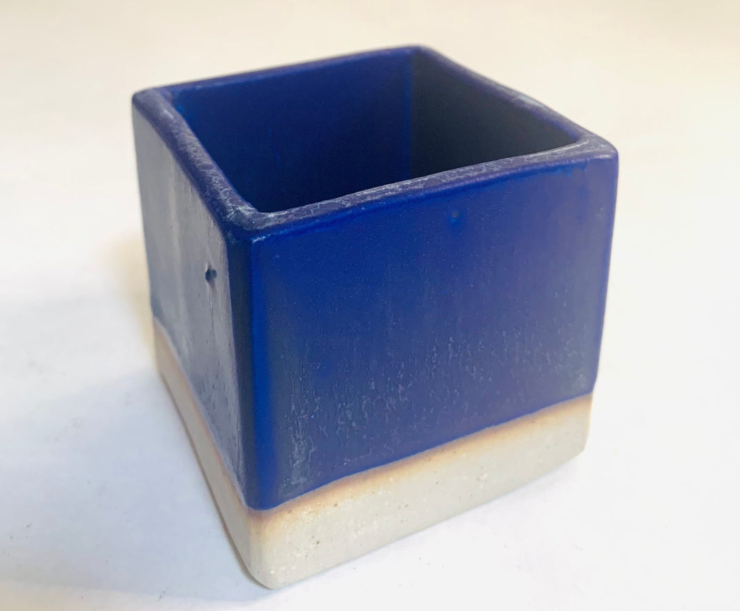 A cube planter with a deep blue glaze. The bottom 1/4th is unglazed.