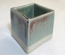 Load image into Gallery viewer, A cube planter with predominantly light blue coloring, with deep red showing through occasionally.
