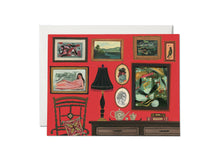 Load image into Gallery viewer, The front of this card depicts a gallery wall filled with beautiful paintings, ranging from abstract to portrait art. There is a rocking chair with a pillow in the lower left corner; and a console table filled with a tea set, a lamp, and books. The largest frame is actually a cut out that leads to the inside of the card.
