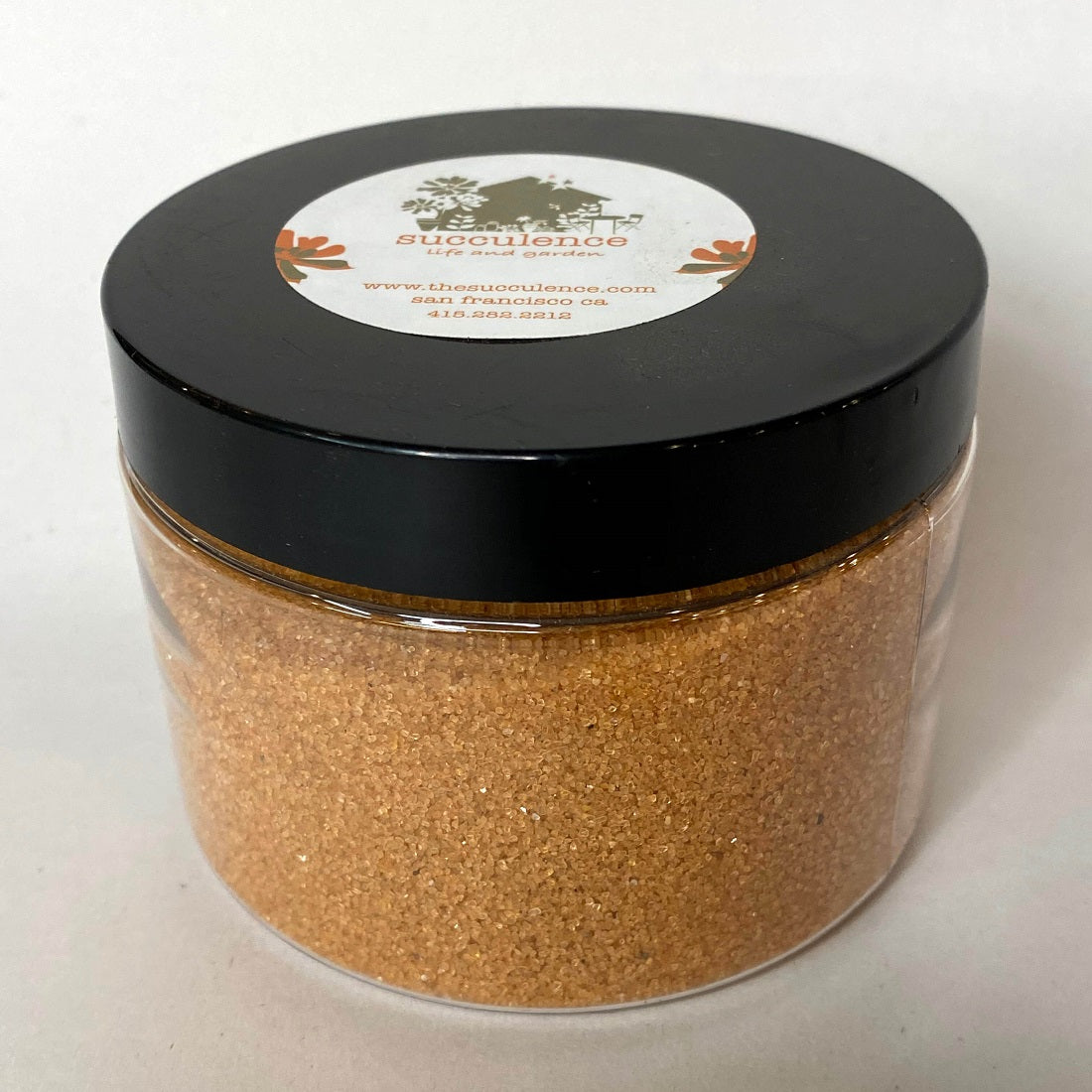 Marigold Sand: a full lidded jar holds coarse yellow-orange sand.