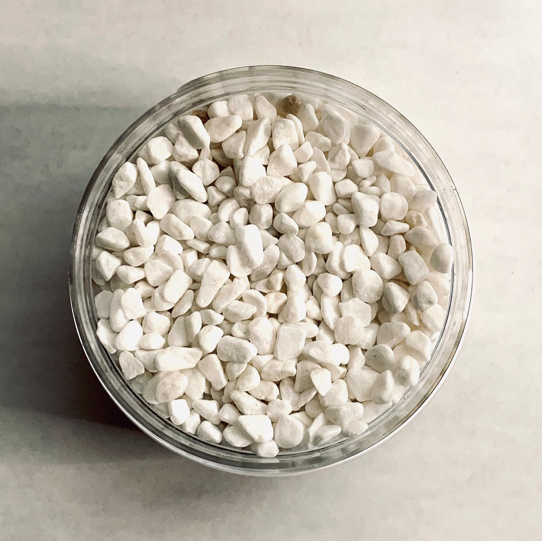 A gods-eye view of a jar of small, white pebbles.