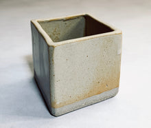 Load image into Gallery viewer, A cube planter with a natural beige color, with small black speckles. The color also varies and veers toward a deep buttery yellow. The bottom 1/8th of the planter is unglazed, retaining its natural grey clay color.
